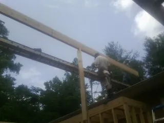 Carpenter setting a ridge beam over a new addition frame — Ice Dam Removal by Roofing Brothers in North Arlington