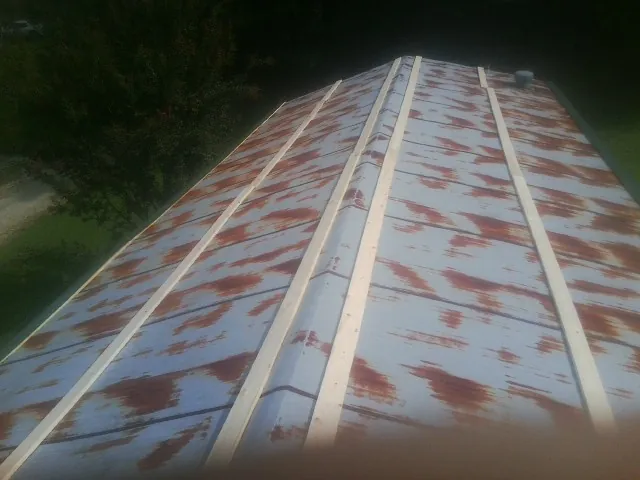 Rusted metal roof panels with new wood purlins before replacement — Storm Damage Roof Repair in North Arlington by Roofing Brothers